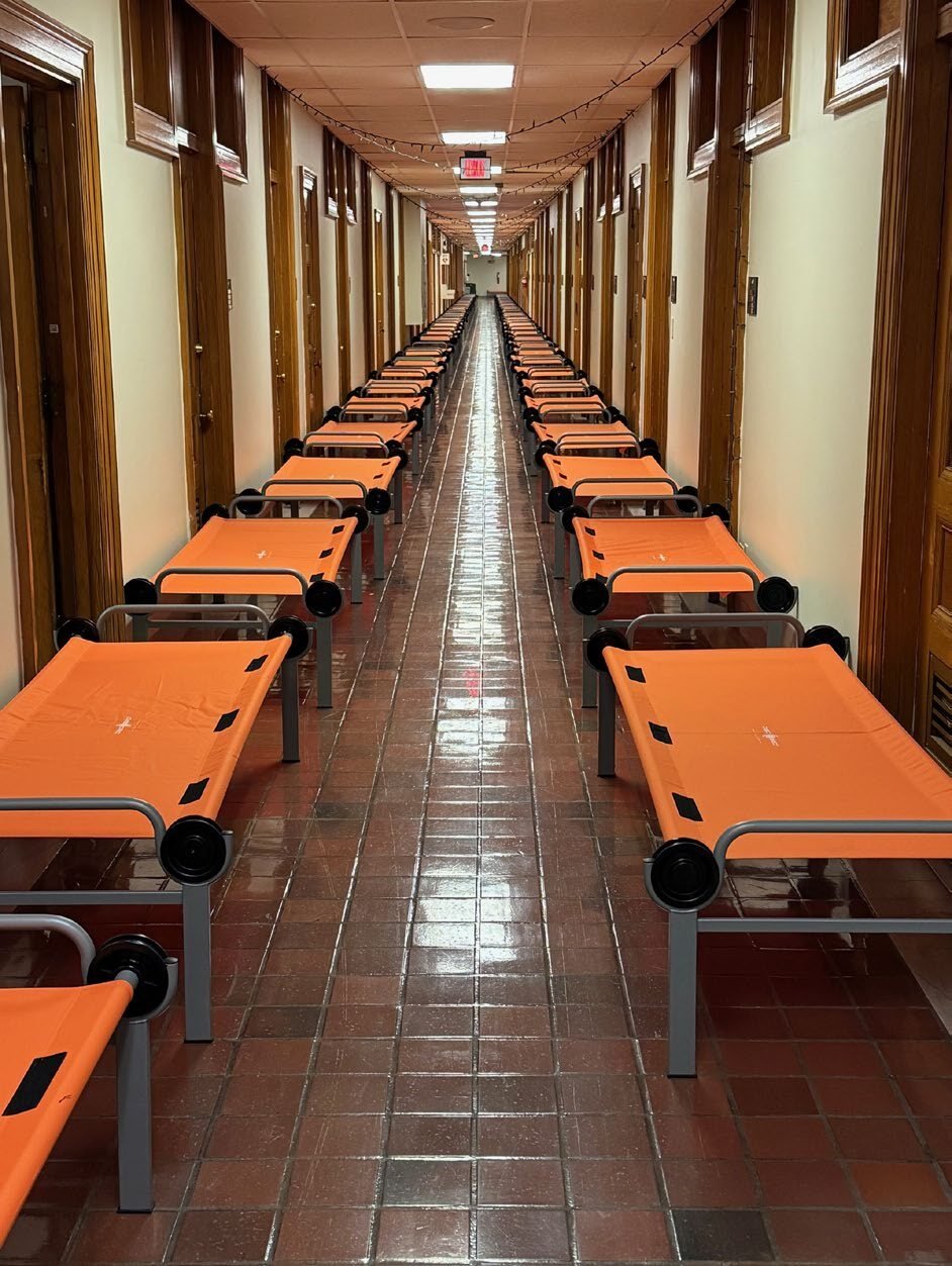 Rows of cots set up for troop billeting.